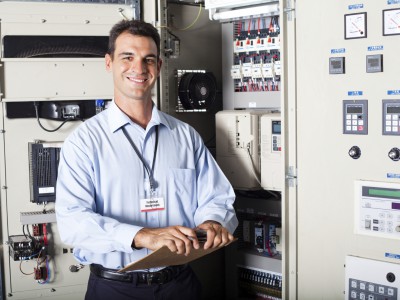 portrait of industrial engineer in front of computerized machinery